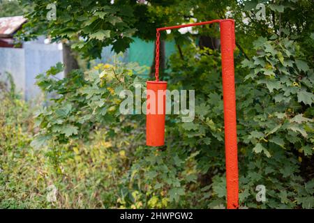 Signal post for warning of fire. Metal stand for impact and extraction of ringing sound. Alarm about disaster on street. Stock Photo