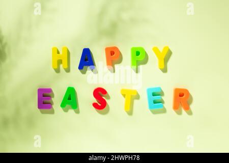 Greeting card with text multicolored HAPPY EASTER on green background Stock Photo