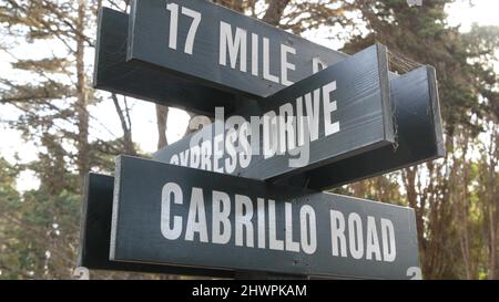 Scenic 17-mile drive wooden road sign, Monterey peninsula, Big Sur, California, USA. Coastal roadtrip, cypress forest. Pacific coast highway tourist route. Hitchhiking trip, ecotourism on vacations. Stock Photo