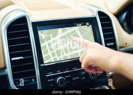 Finding locations the efficient and easy way. Shot of an unrecognizable woman using a gps in a car. Stock Photo