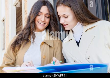 Smiling students studying together on campus Stock Photo