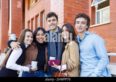 Happy multiracial students standing on college campus Stock Photo
