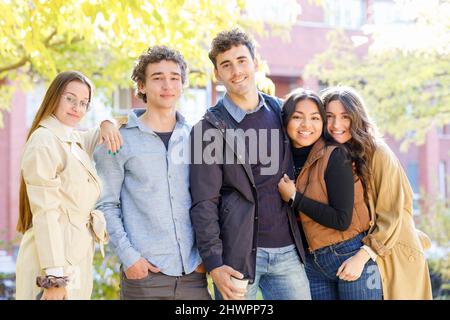 Happy multiracial students standing on university campus Stock Photo