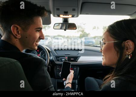 Young business colleagues looking at each other sitting in car Stock Photo