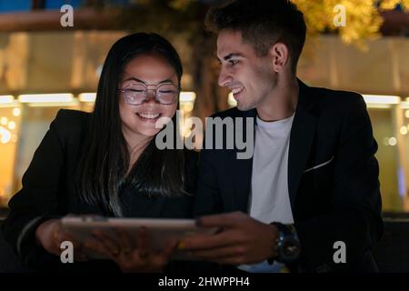 Happy multiracial business colleagues holding tablet PC Stock Photo
