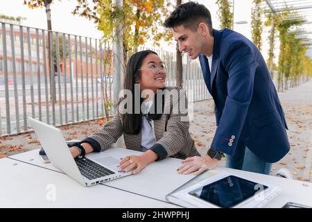 Business colleagues discussing over laptop at table Stock Photo