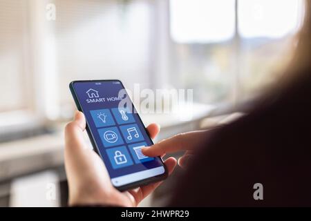 Woman touching device screen with smart home application Stock Photo