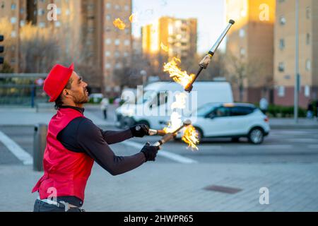 Street performer juggling flaming torches in city Stock Photo