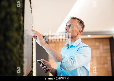 Businessman pointing at touch screen computer monitor in coworking office Stock Photo