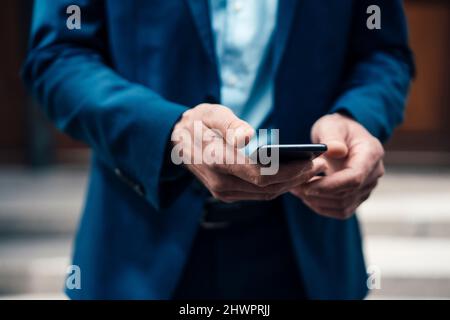 Businessman text messaging through smart phone Stock Photo