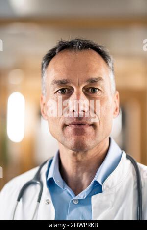 Confident mature doctor in lab coat at hospital Stock Photo
