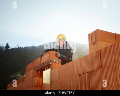 Construction worker fixing bricks at construction site Stock Photo