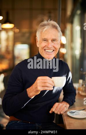 Smiling senior man having coffee in cafe Stock Photo