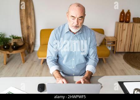Serious businessman using laptop at desk Stock Photo