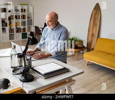 Senior businessman using laptop working from home Stock Photo