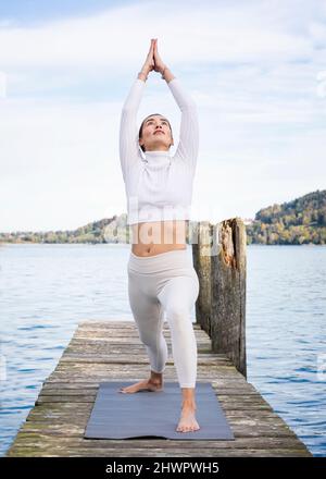Active woman stretching hands on jetty Stock Photo