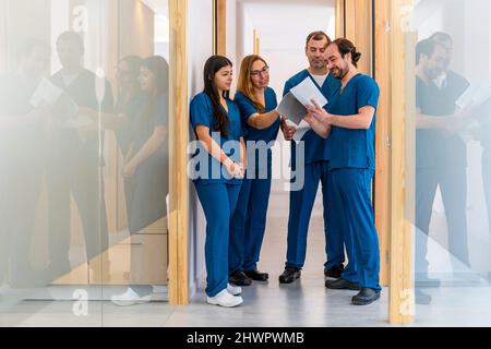 Nurse discussing with doctor over medical record at hospital Stock Photo