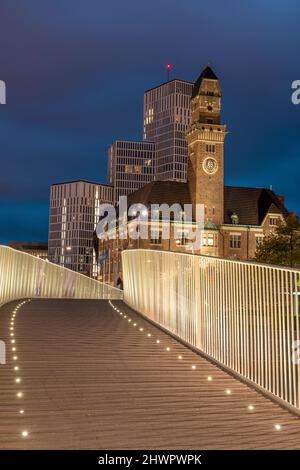 Sweden, Skane County, Malmo, Illuminated bridge at night with World Maritime University and hotels in background Stock Photo