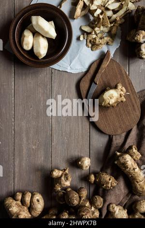 Jerusalem Artichoke and knife on cutting board in studio Stock Photo