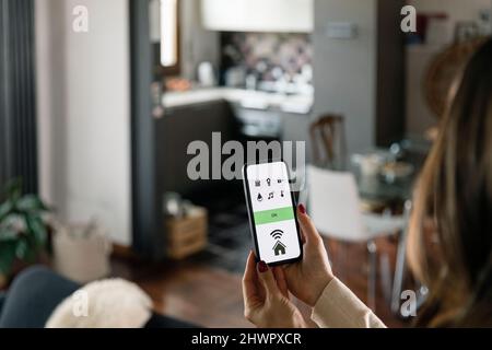 Woman using app on smart phone at home Stock Photo