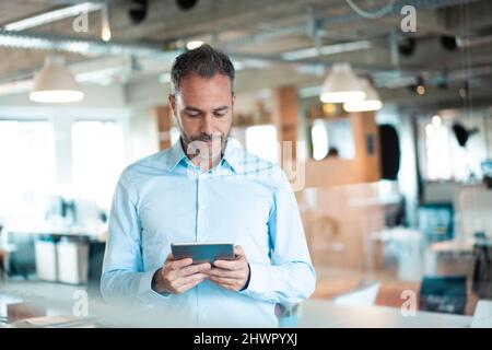 Dedicated working man using tablet computer at workplace Stock Photo