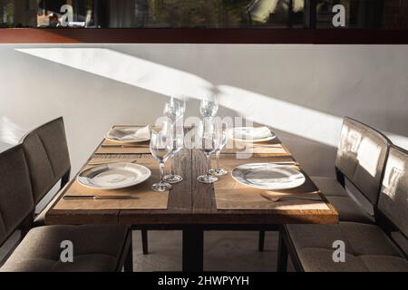 Wineglasses and plates arranged on table in restaurant Stock Photo