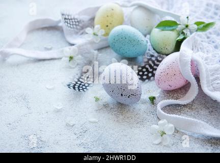 String bag with Easter eggs and spring blossom on concrete background Stock Photo
