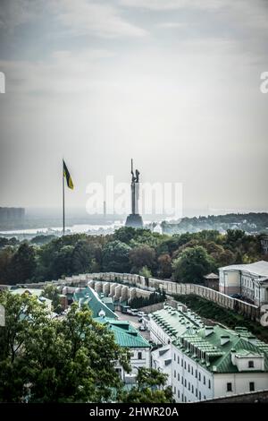Kiev, Ukraine – October 10th, 2020: Panoramic view of Kiev with the Motherland Monument and Ukrainian flag visible in the background Stock Photo