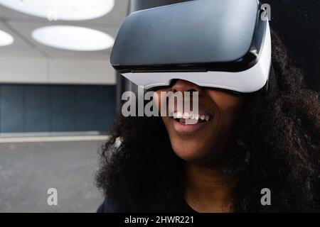 Smiling woman wearing virtual reality simulator Stock Photo