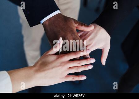 Multi-ethnic business colleagues stacking hands Stock Photo