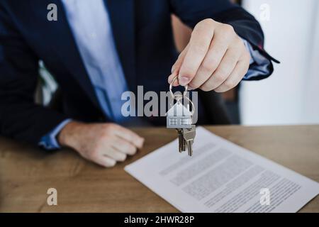 Businessman holding bunch of house keys in office Stock Photo
