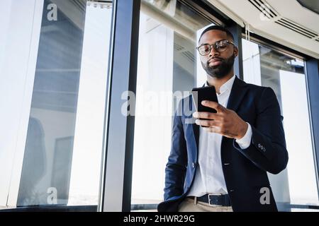 Businessman using smart phone in office Stock Photo