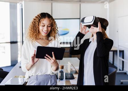 Young business colleagues using wireless technologies in coworking office Stock Photo