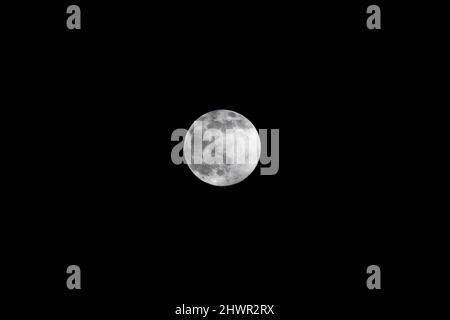 Full moon glowing against clear sky at night Stock Photo