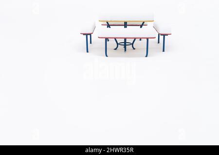 Empty bench and table covered in snow at public park Stock Photo