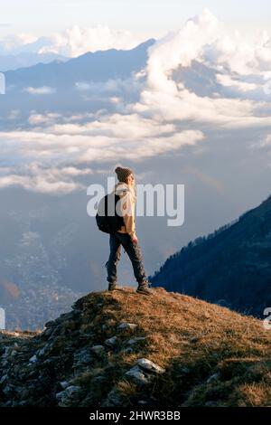 Young woman with backpack standing on cliff at Caucasus Nature Reserve in Sochi, Russia Stock Photo