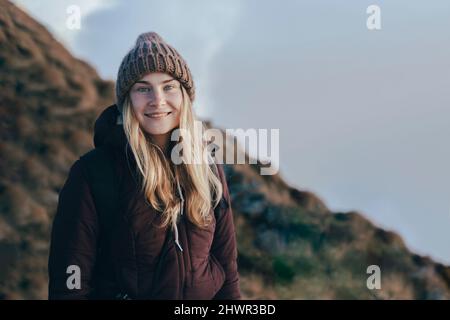 Smiling young tourist in knit hat at Caucasus Nature Reserve in Sochi, Russia Stock Photo