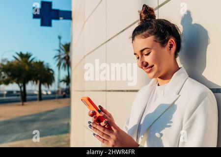 Smiling woman using smart phone Stock Photo