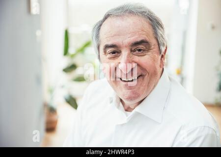 Smiling senior man with gray hair at home Stock Photo