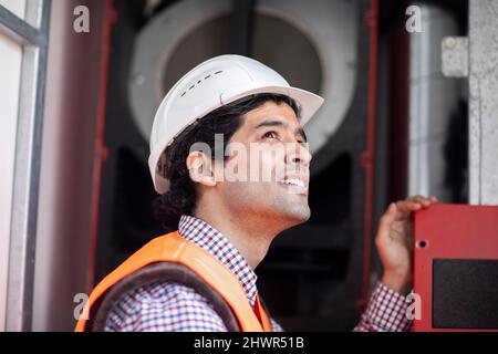 Engineer wearing hardhat working at machinery Stock Photo