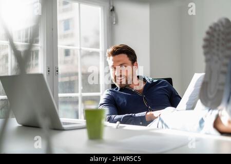 Businessman with document using laptop at office Stock Photo