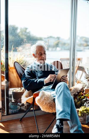 Senior man surfing net through tablet PC at houseboat Stock Photo