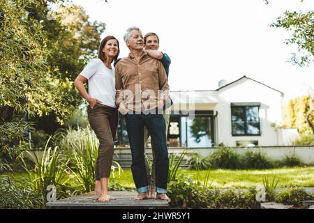 Happy family standing together in garden Stock Photo