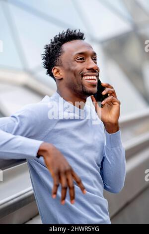 Happy man with black hair talking on smart phone Stock Photo