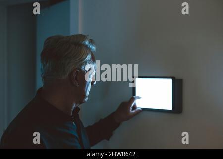 Senior man using smart home app on table PC at home Stock Photo