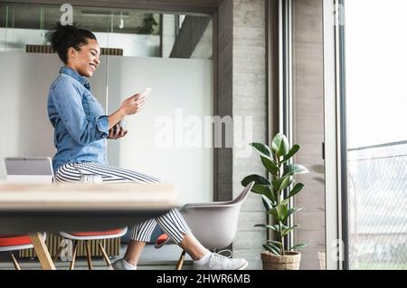Businesswoman using smart phone at work place Stock Photo