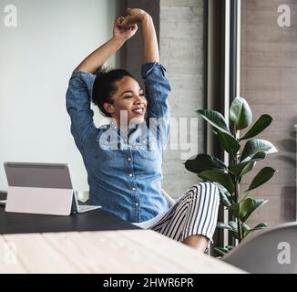 Young businesswoman stretching hands in office Stock Photo