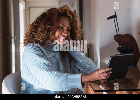 Young woman using tablet PC at home Stock Photo