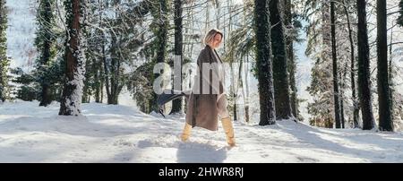 Woman walking on deep snow in forest Stock Photo