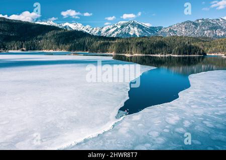 Germany, Bavaria, Aerial view of lone man paddleboarding between ice floes in Eibsee lake Stock Photo